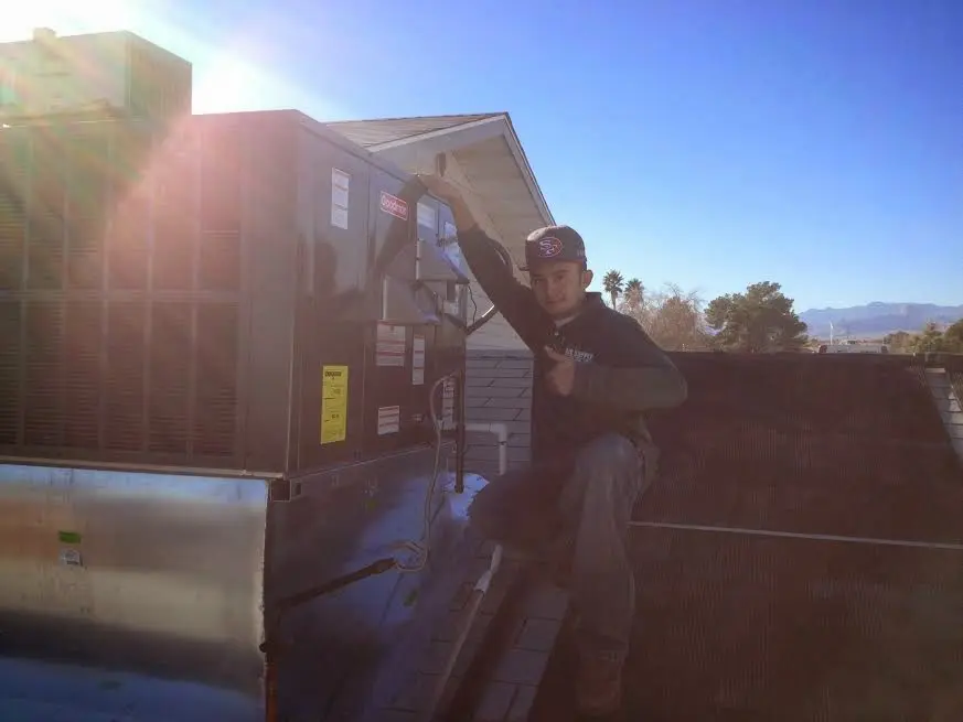 HVAC technician performing AC Tune-Up on a rooftop unit in Hillside